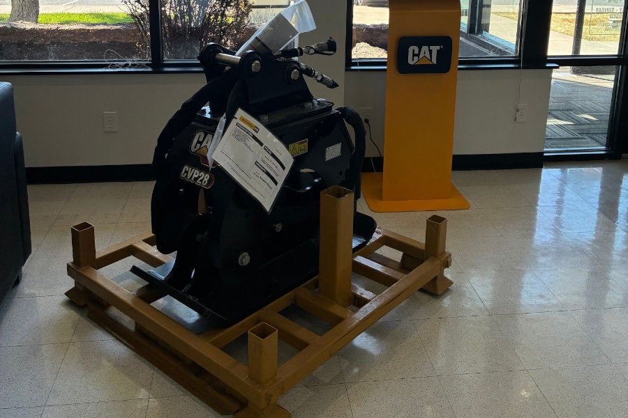 A Cat CVP28 vibratory plate compactor attachment for compacting soil in trenches and around foundations