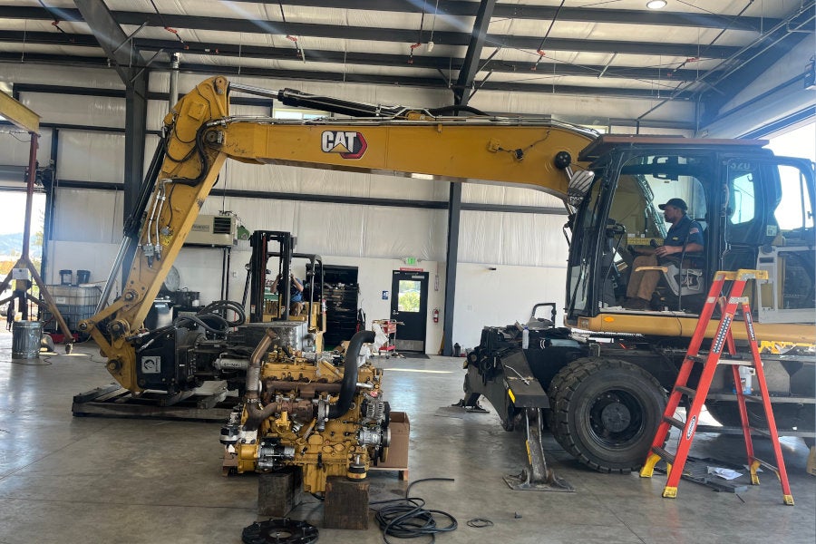 A Cat M320 Wheeled Excavator with a Rotobec grapple.