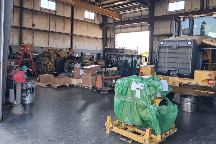 A Cat wheel loader is having its engine replaced in a heavy equipment shop