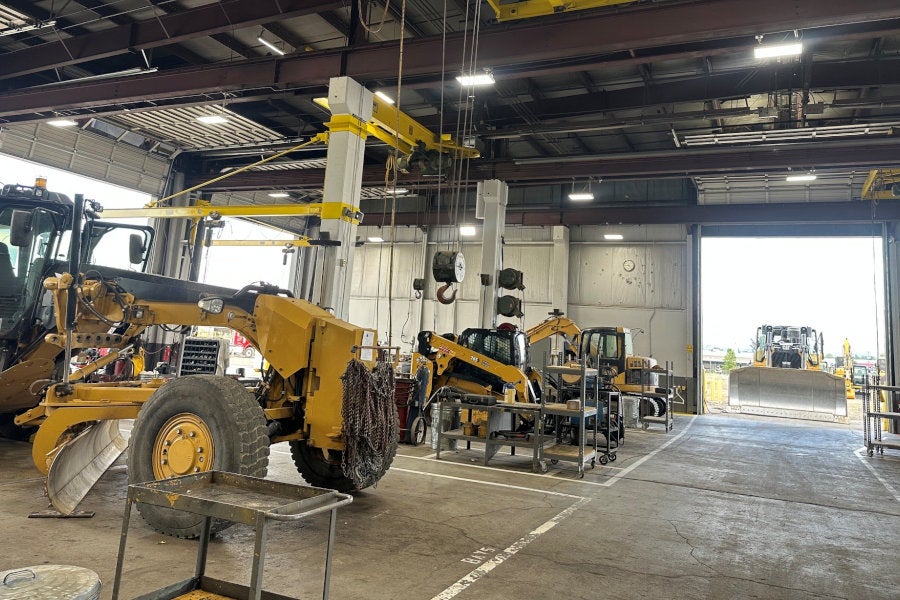 Service shop with a motor grader, compact track loader, mini excavator, and a dozer