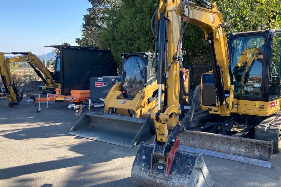 A Cat compact track loader, varriable message board, air compressor, and two Cat mini excavators on the rental-ready line