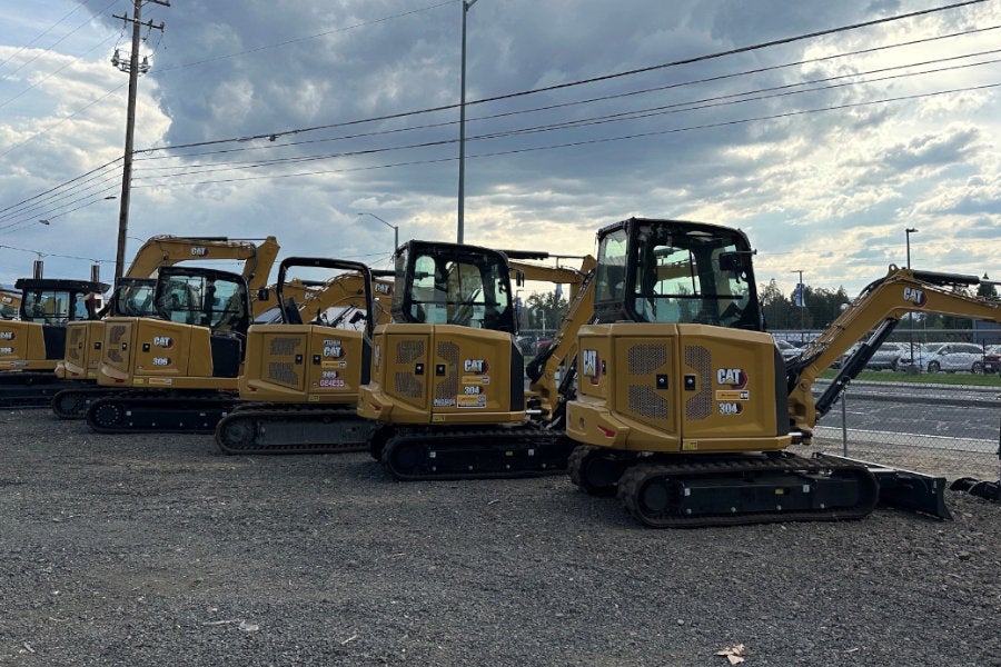 A line of six new Cat mini excavators facing Biddle Road