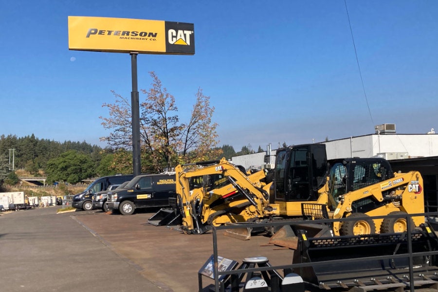 new and used skid steer loaders, mini excavators, and attachments parked outside beside the Eugene store
