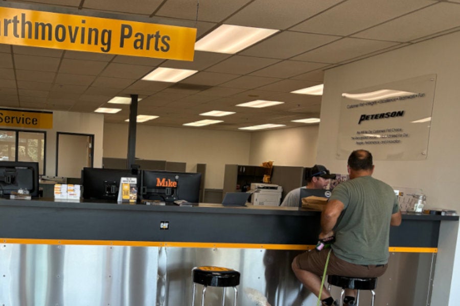 Customer and employee sitting at the Peterson Cat parts counter in Redmond