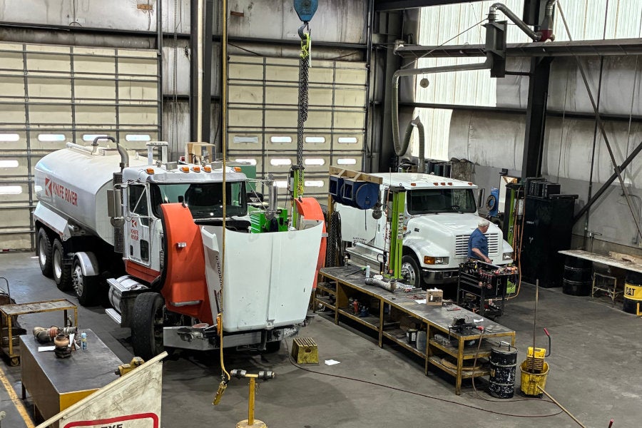 A Peterson technician brings a tool cart to one of two commercial trucks in the Redmond shop