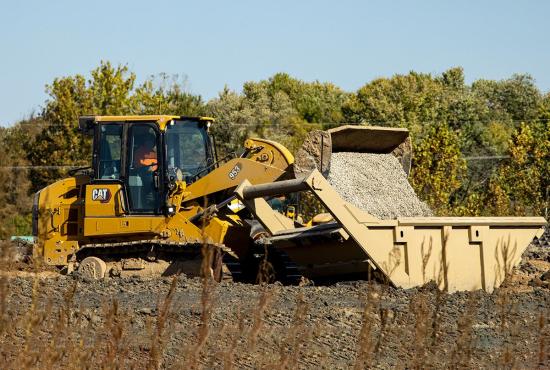 Cat 953 crawler loader dumping gravel