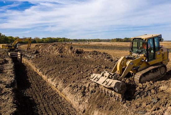 Cat 953 crawler loader filling a trench