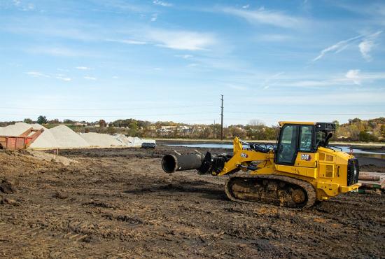 Cat 963 track loader carrying pipe on a utility job