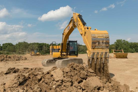 320 GC Excavator dumping a bucket of dirt