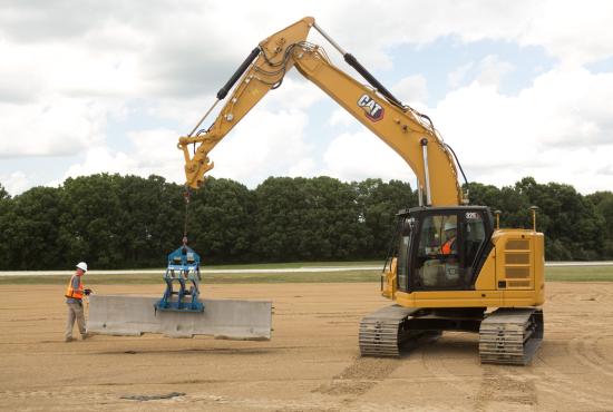 325 Hydraulic Excavator lifting a concrete barrier