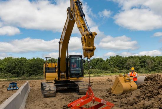 323 Hydraulic Excavator setting concrete drainage pipe