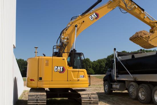 325 Hydraulic Excavator digging near a wall