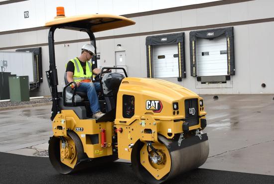 CB2.7 tandem vibratory roller compacting asphalt in a parking lot.