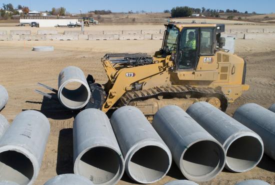 The 973 crawler loader with forks stages pipe for underground utility installation