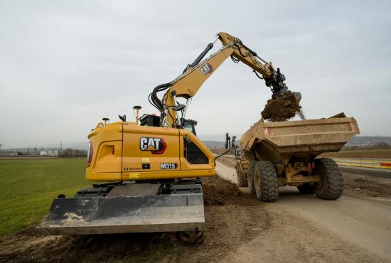 M315 Wheel Excavator loading dirt in a truck