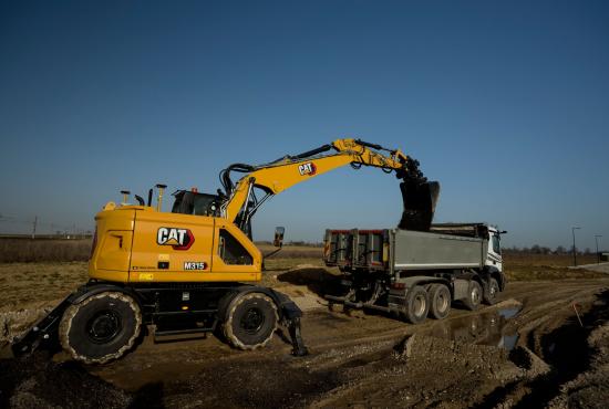 M315 Wheel Excavator loading dirt in a truck