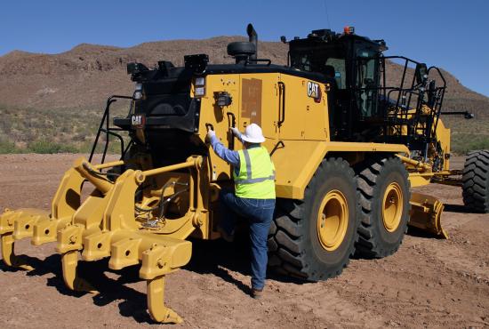 Operator climbing onto 16 motor grader