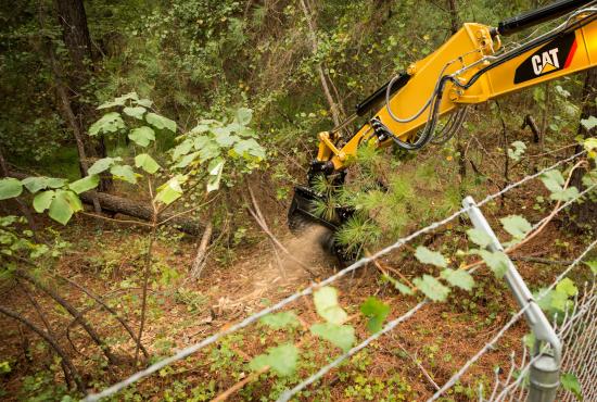 Cat® HM210 Mulcher Clearing Brush on Over a Fence