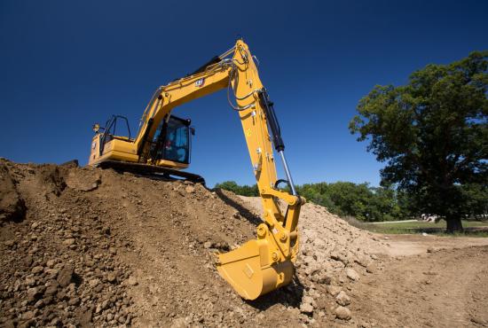 Cat 313 hydraulic excavator grading on slope at a construction site.