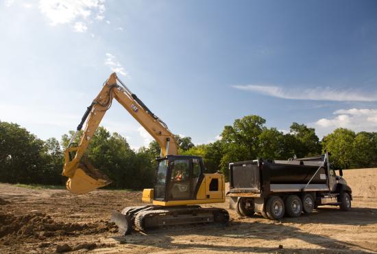 Cat 313 hydraulic excavator loading material into a dump truck at a construction site.